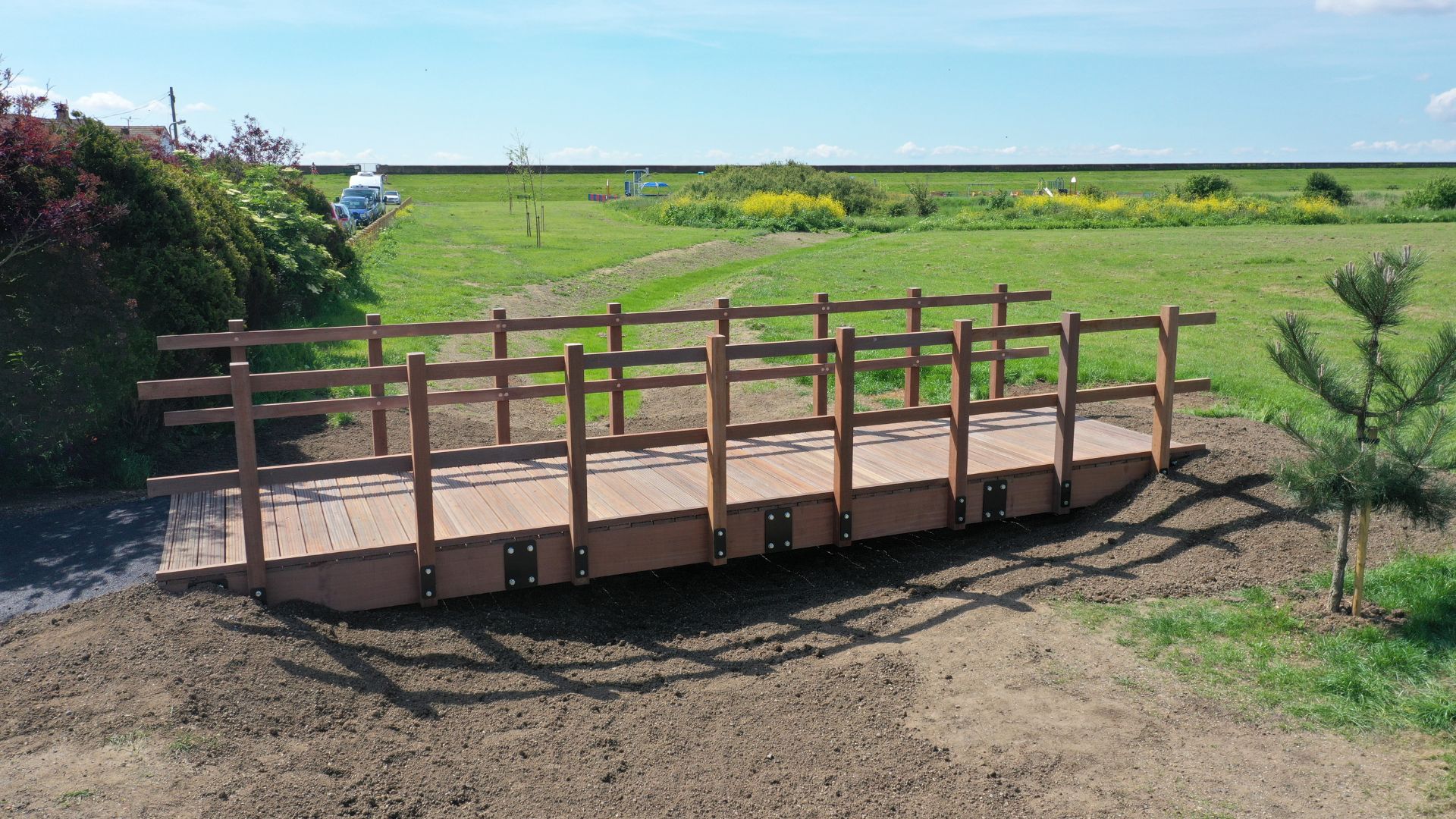 Wooden footbridge with green fields in the background