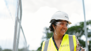 Female civil engineer on site in a high-vis vest and white hard hat