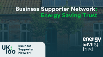 UK100 Business Supporter Network banner featuring Energy Saving Trust logo against a background of residential buildings with solar panels on rooftops