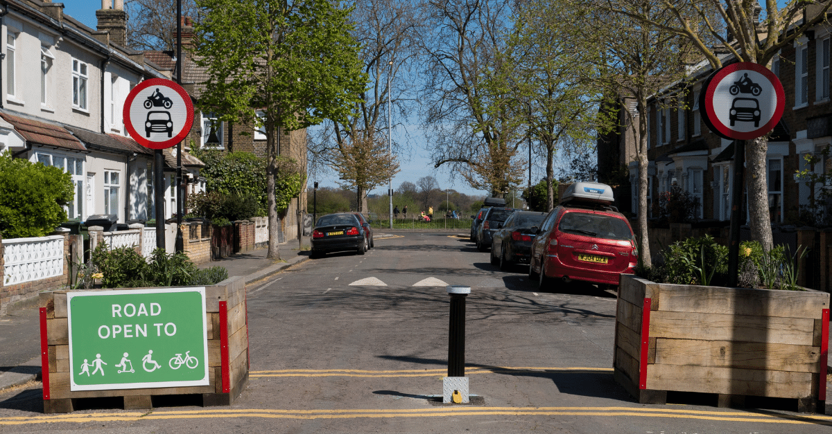A residential, tree-lined street in a low-traffic neighbourhood on a sunny day in England