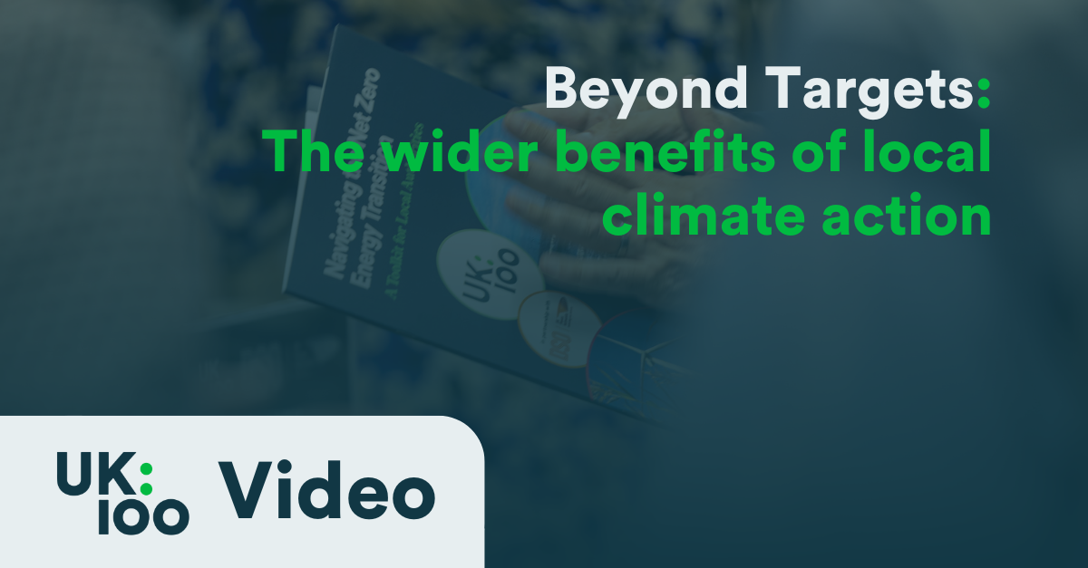 "Beyond Targets conference graphic showing UK100 logo and title 'Beyond Targets: The wider benefits of local climate action' with blurred conference attendee in background"