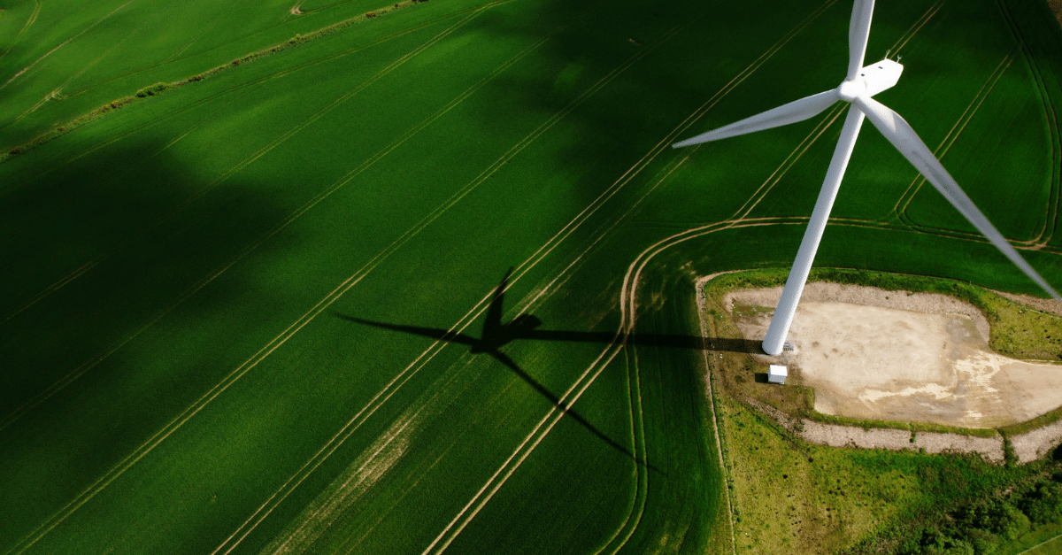Aerial shot of the wind turbine next to a field